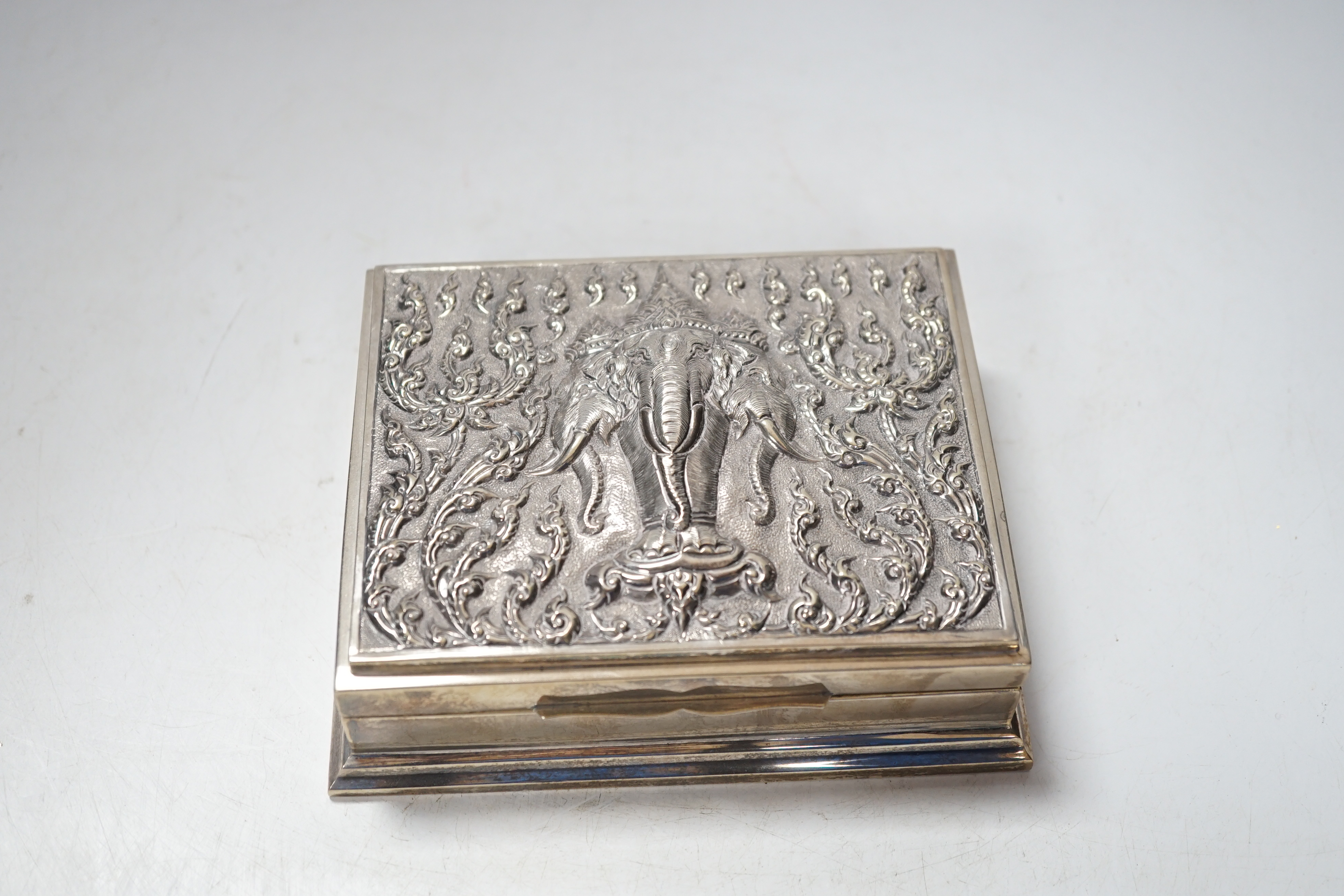 A Thai white metal cigarette box, stamped sterling, 14cm, and a similar sterling overlaid photograph frame, width 16cm